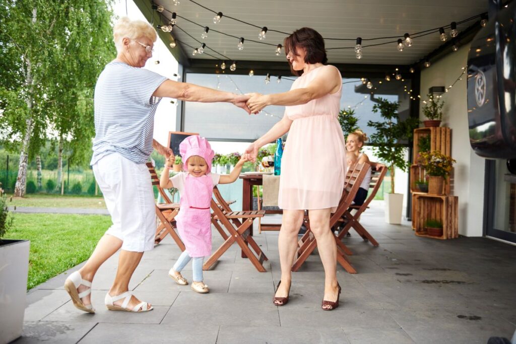 Mature woman feeling good enough to dance with daughter and granddaughter on an outdoor patio after she received non-invasive varicose veins treatment in Lakewood Ranch.